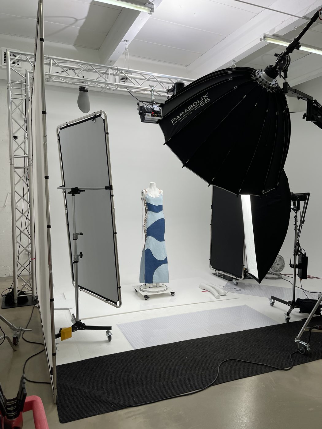 Garment on a mannequin lit by a large parabolic softbox against a white cyclorama