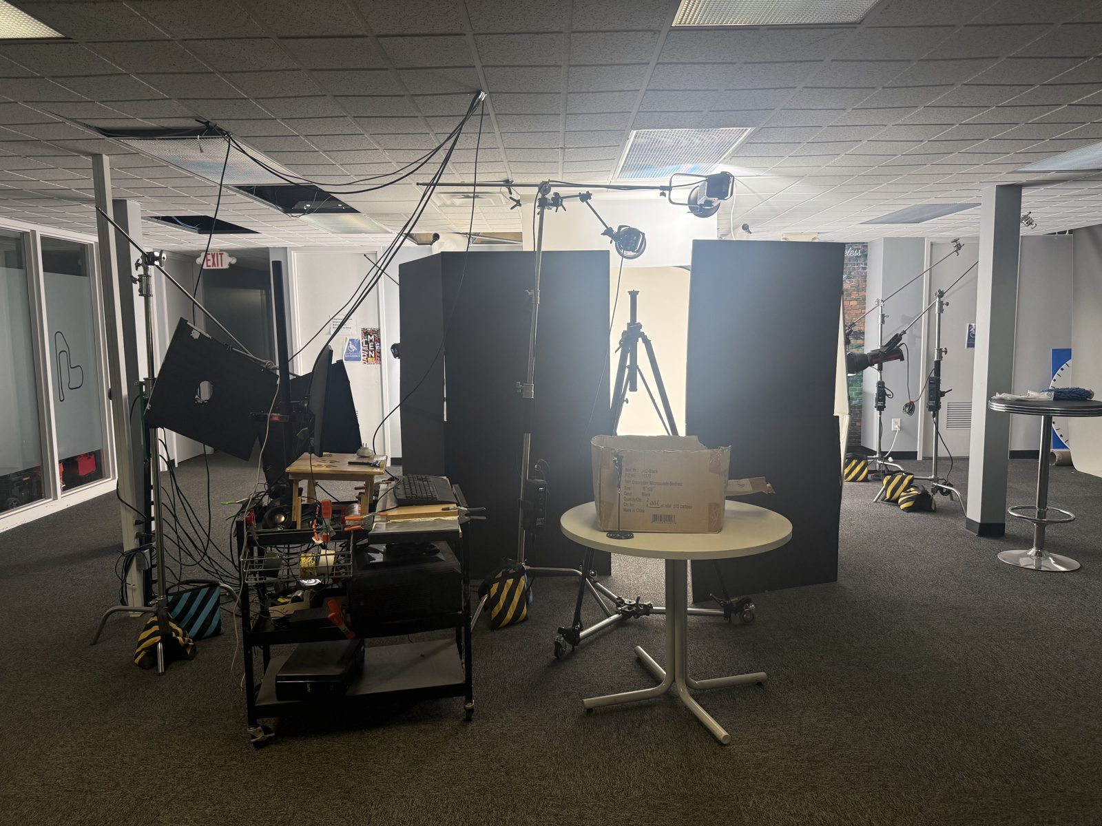 Photo studio set up with black flags, seamless backdrop, strobes and a tethering cart